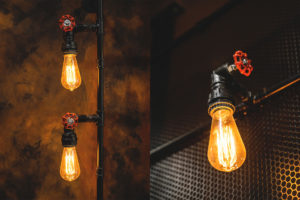 Rust painted wall with mesh and pipework with feature lighting. Pipework details with integrated lighting fixtures.