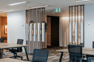 Feature screen between workspace and waiting area. Solid white laminate panels with floating resin blocks in between.