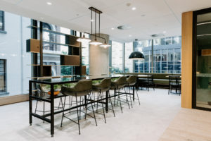 Break out area with Fat shack vintage Printmaker Rod pendant light, Vorsen Coco kitchen stool and custom shelving storage unit. Green banquette seating. Bespoke High table with glass top and shelf for pot plants.