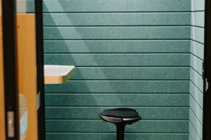 Phone Booth room with Autex acoustic panels and mirror panel. Standing height desk with stool.