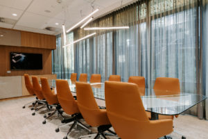 Boardroom table created with preserved moss feature element. Glass table top with Preserved moss river through centre. Leather boardroom chairs from FDB Commercial. Feature pendant lighting over table. TV unit created from timber and colour back glass with storage incorporated.