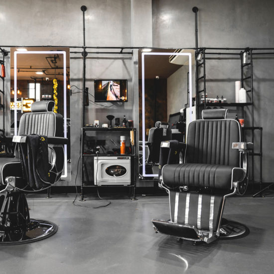 Barber chair with LED mirror and feature pipework structure to create shelving.