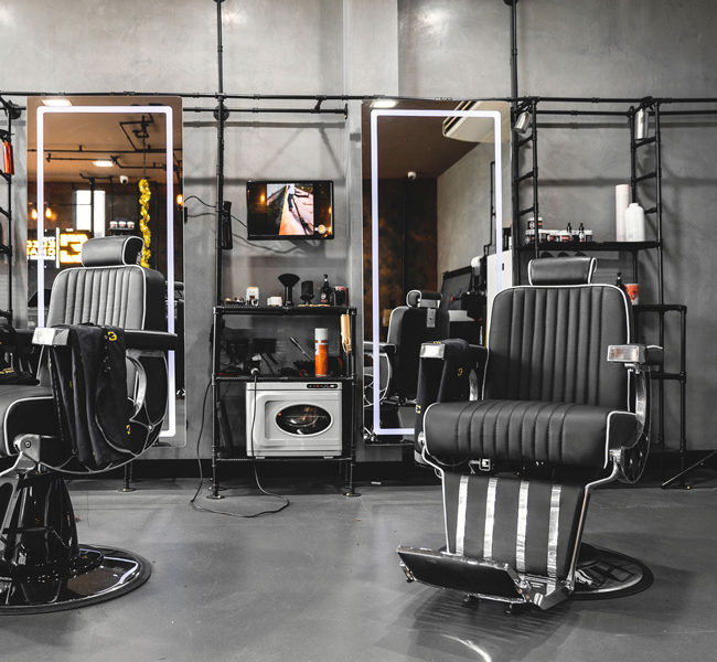 Barber chair with LED mirror and feature pipework structure to create shelving.